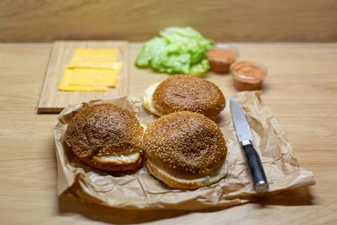 Burger bread, lettuce and cheese on the table. Process of cooking self made b Stock Photos