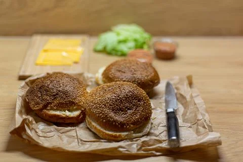 Burger bread, lettuce and cheese on the table. Process of cooking self made b Stock Photos