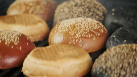 Burger bun is fried on a grill grid. Vídeo Stock 154760244