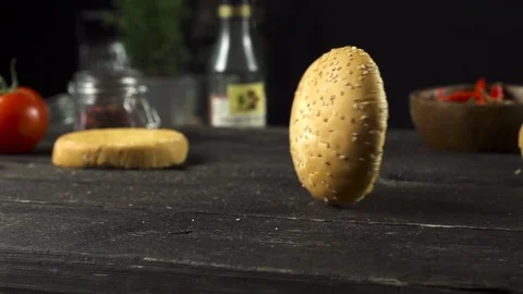 Burger bun is spinning on the kitchen table slow motion 動画素材 104973009