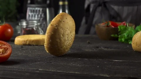 Burger bun is spinning on the kitchen table slow motion 動画素材 104974585