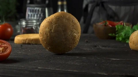 Burger bun is spinning on the kitchen table slow motion Video stock 104974597