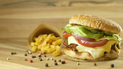 Burger Cheese burger with succulent beef and fresh salad ingredients on a rustic Stock Footage 97243653