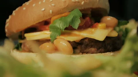 Burger Cheeseburger with succulent beef and fresh salad ingredients on a rustic  Video stock 86124362
