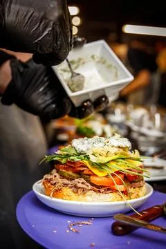 Burger cooking process. Chef mixing ingredients and sauce. Stock Photos