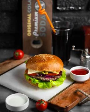 Burger with cotlet, cabbage, cheese and tomato served with ketchup Stock Photos
