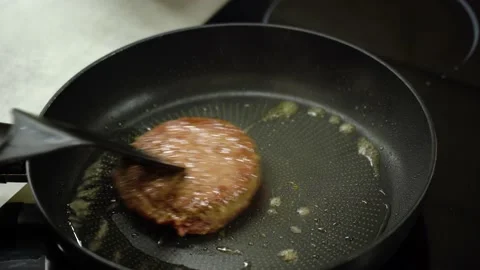 Burger cutlet is turned over with spatula and fried in frying pan Vidéo 232892887