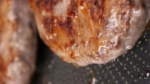 Burger cutlets are fried in a black frying pan, side view. Stock-Footage 229456906