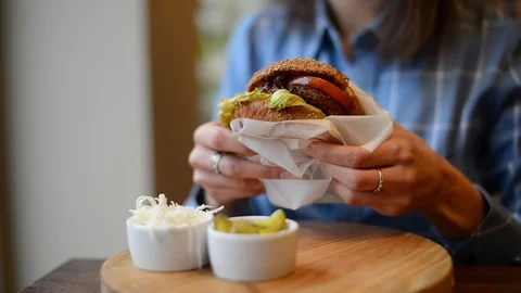 Burger in female hands close up leaking Stock Footage 101116685