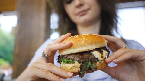Burger in female hands close up leaking Stock Footage 105186939