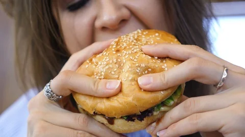 Burger in female hands close up leaking Stock Footage 105187771
