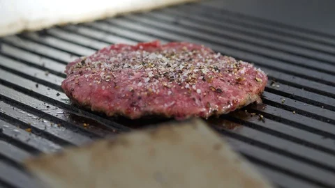Burger flipped on the stone grill. Preparing of the burger Stock Footage 86177208