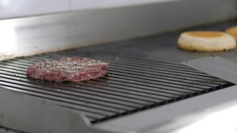 Burger flipped on the stone grill. Preparing of the burger Stock Footage 86178483