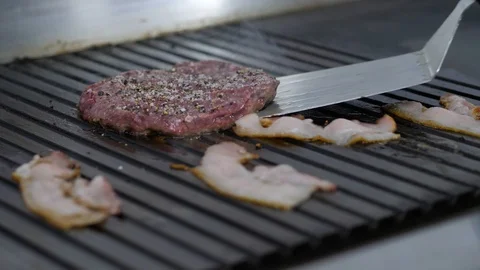 Burger flipped on the stone grill. Preparing of the burger Stock Footage 86178641