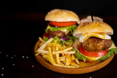 Burger, hamburger with egg or cheeseburger served with french fries, pickles Stock Photos