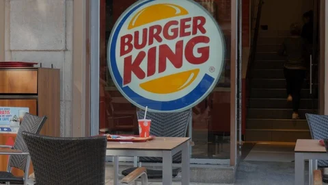 Burger king facade. In the foreground an outdoor table on the terrace Stock Footage