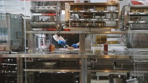 Burger King open kitchen behind glass in restaurant staff preparing fast food 스톡 동영상 331841042
