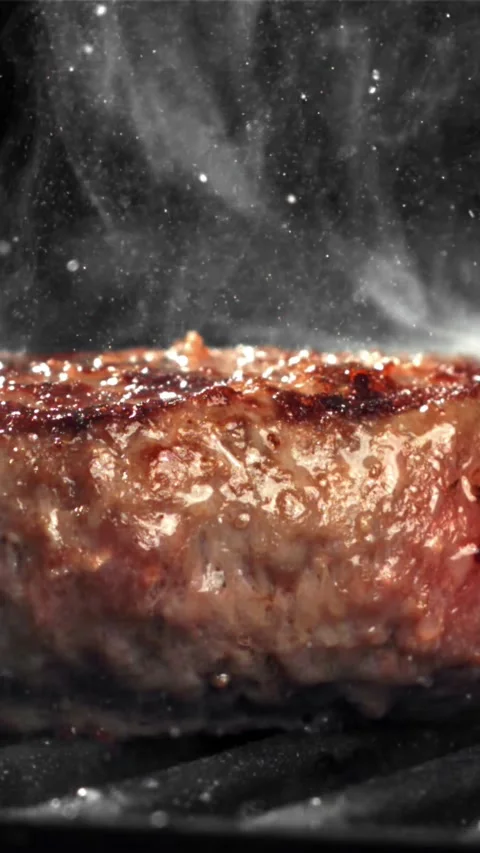 A burger made from natural meat is fried in a frying pan. Filmed on a high-speed Stock Footage 335322872