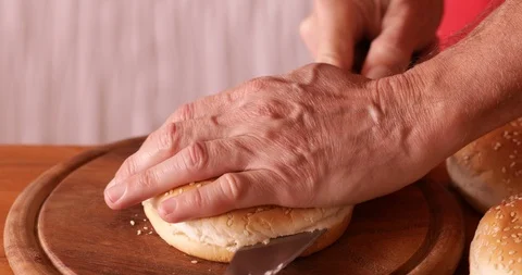 Burger making - cutting burger bun, close-up Stock Footage 107904299