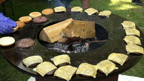 Burger meat, cheese and bread baking on outdoor grill. Slow motion shot. Stock Footage 109504615