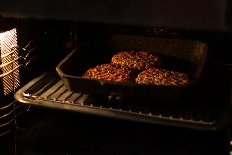 Burger minced beef meat in oven. Process of burger cooking at home Stock Photos
