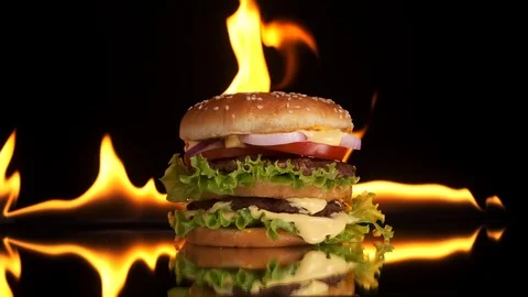 Burger on a mirror surface, the fire is burning in the background. Stock Footage 125637335