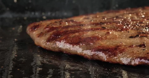Burger patty on the grill in fire. Hamburger or cheeseburger preparation. Party Stock Footage 293536446