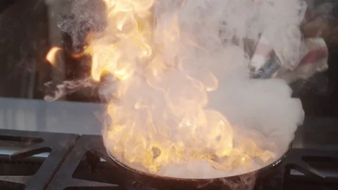 Burger patty overturned in pan in blazing fire in slow motion Stock Footage 123366643