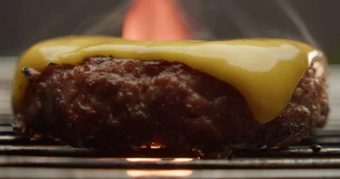 Burger patty with a slice of cheese fried over a fire macro Stock Footage 310958610