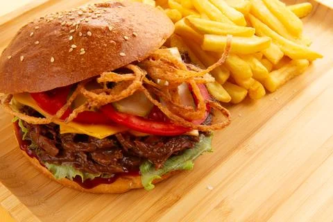 Burger with pulled beef, onion rings and fries. Stock Photos