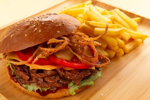 Burger with pulled beef, onion rings and fries. Stock Photos