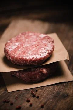 Burger steak cutlets ready to prepare on rustic table Stock Photos
