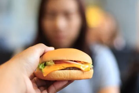 Burger in young man hands select focus blur background, Young man holds burge Stock Photos