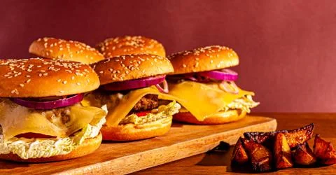 Burgers on a wooden board with potatoes. Tasty photo fast food. Place for tex Stock Photos