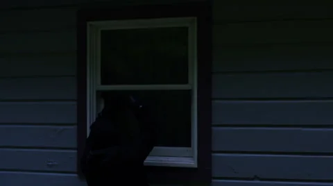 Burglar attempts to open a window with a pry bar Stock Footage 44103713
