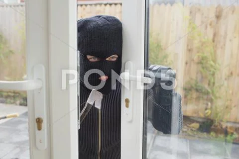 Burglar opening the door Stock Photos