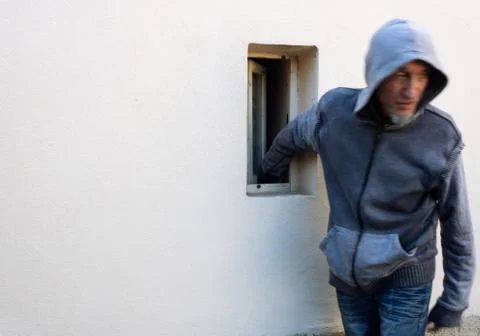 Burglar or thief or robber with face motion blur is stealing with arm through Stock Photos