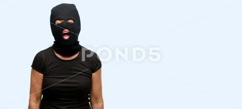 Burglar terrorist woman wearing balaclava ski mask stressful, terrified in pa Stock Photos