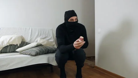 Burglary and entry with the intent to commit a crime. A masked thief sneaks into Video stock 144211497