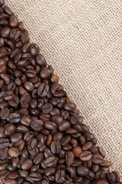 Burlap background with coffee beans. Stock Photos