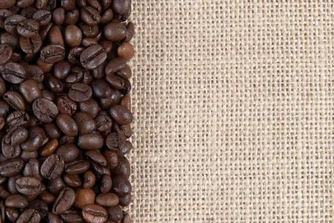 Burlap background with coffee beans. Stock Photos