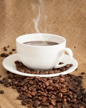 Burlap background with coffee cup and coffee beans Stock Photos