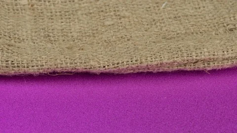 Burlap on a bright pink background. Rotation. Stockbeeldmateriaal 129590940