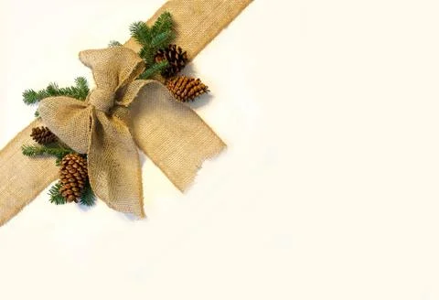 Burlap christmas bow and pine cones frame on white background Stock Photos