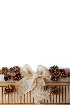 Burlap christmas bow and pinecones isolated on white background Stock Photos