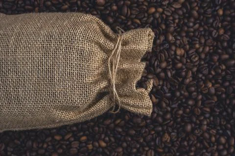 Burlap sack on roasted coffee beans background Stock Photos