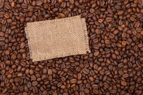 Burlap tag on the background of coffee Stock Photos