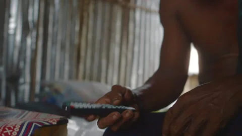 Burmese man using a remote control in a bamboo hut in Myanmar Video stock 332754752