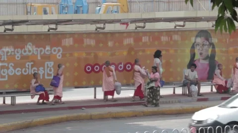 Burmese Monks In front of Bus Stop with Modern Advertisment Stock Footage 56632443