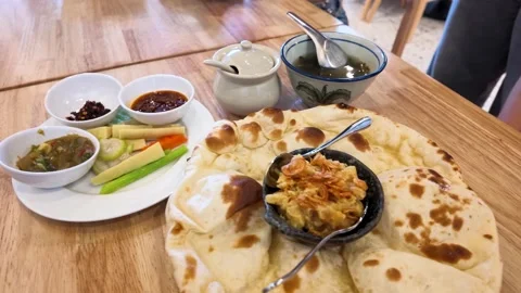 Burmese Naan Flatbread Served with Chickpea Curry and Condiments Stock Footage 345100496